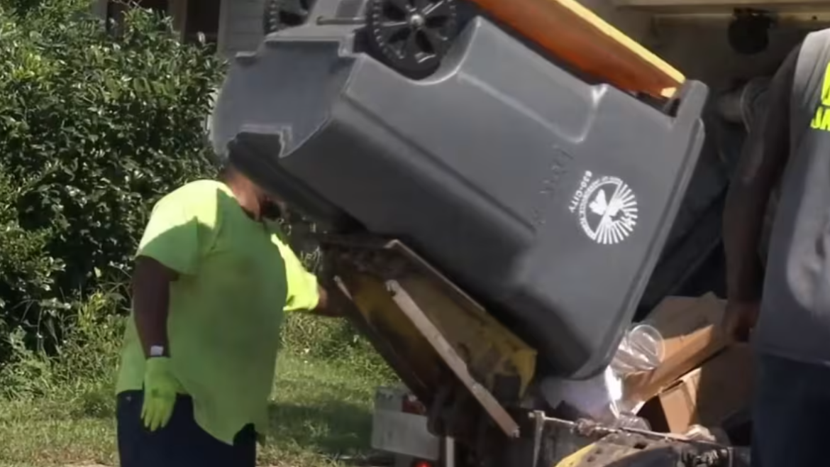 A solid waste employee collects garbage in Jacksonville. 