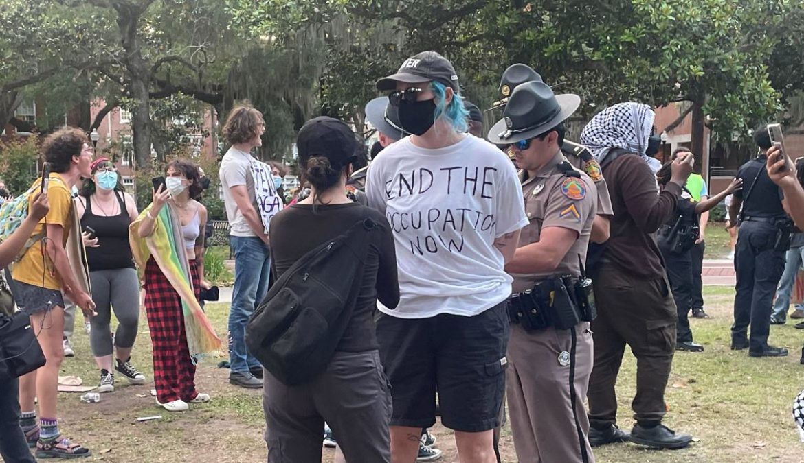 Policiais não identificados da Patrulha Rodoviária da Flórida prendem um dos nove manifestantes pró-palestinos no campus da Universidade da Flórida na noite de segunda-feira, 29 de abril de 2024.
