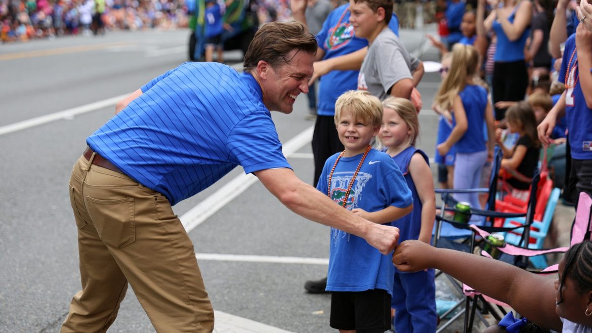University of Florida President Ben Sasse fist-bumps kids during UF's Homecoming Parade in Gainesville in 2023. 