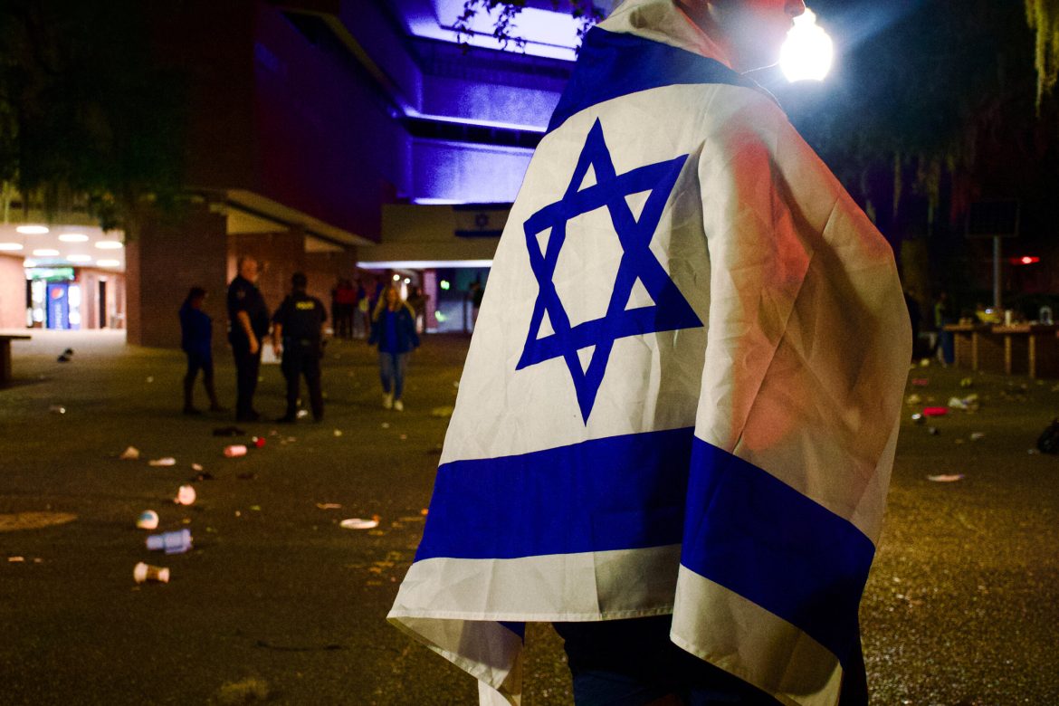 An unidentified University of Florida student wraps himself in an Israeli flag during a campus vigil Oct. 9, 2023, for victims of Hamas attacks. 
