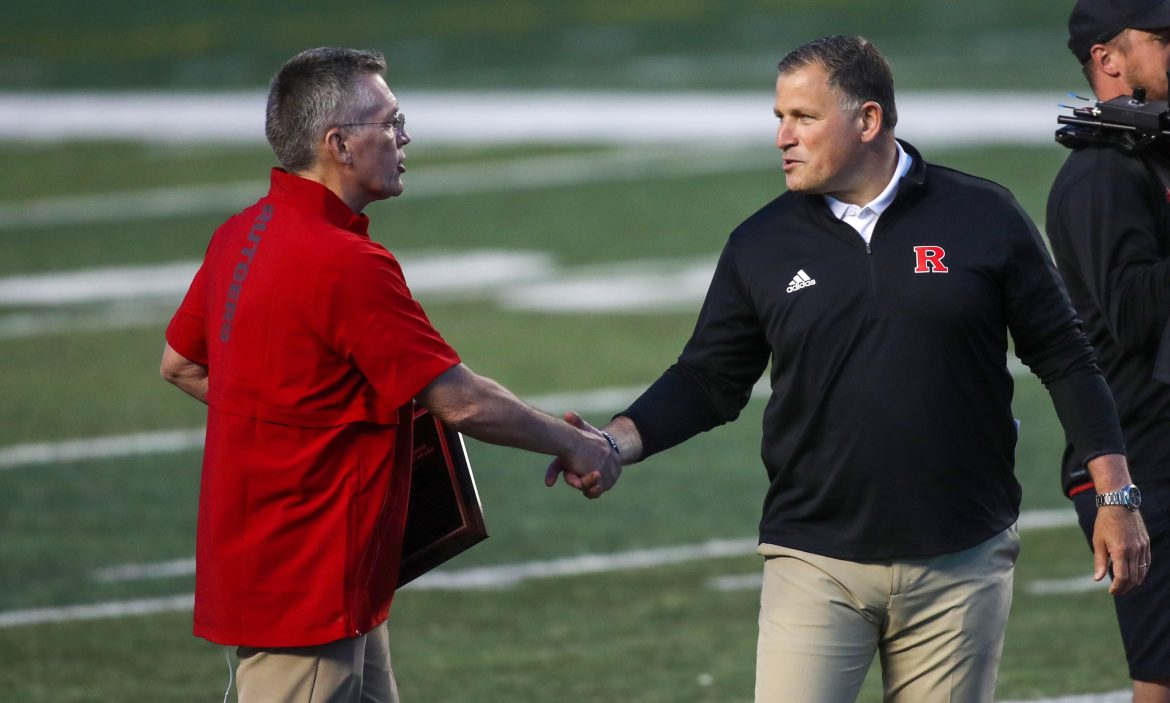O ex-diretor atlético da Rutgers, Pat Hobbs (à esquerda), aperta a mão do técnico Greg Schiano no intervalo do jogo de primavera entre Rutgers Scarlet e White em 2021. 