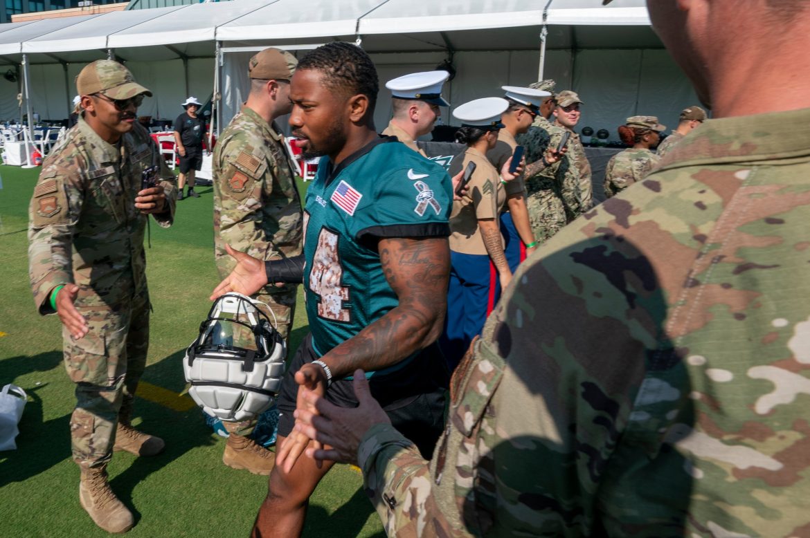 O running back do Philadelphia Eagles, Kenneth Gainwell, sai para treinar através de uma fila de boas-vindas militar durante o treino no campo de treinamento de futebol americano da NFL, sábado, 27 de julho de 2024, na Filadélfia. (Foto AP/Chris Szagola)