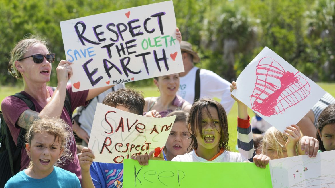 Protesters chant against a plan to develop state parks with business ventures such as golf courses, pickleball courts and large hotels, during a demonstration at Oleta River State Park on Tuesday, Aug. 27, 2024, in North Miami Beach. 