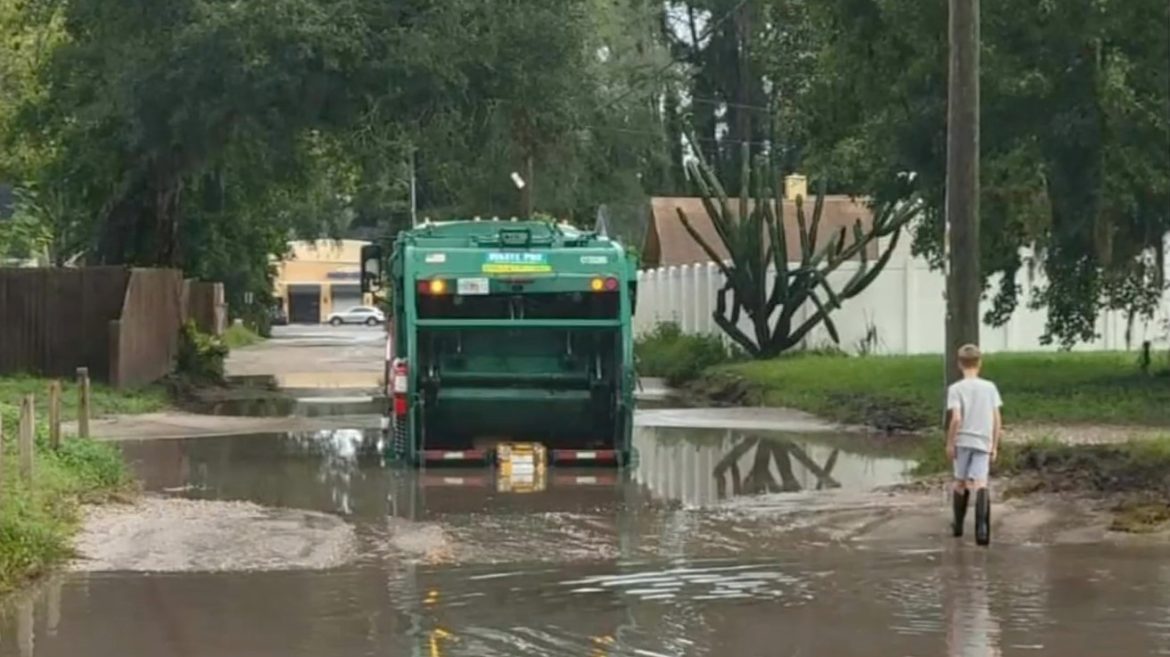 A garbage truck plows through a flooded road in the city's Sans Pareil neighborhood. 