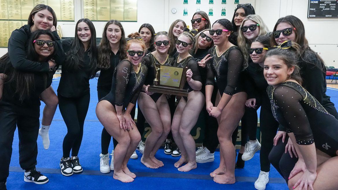 Ginastas de St. John Vianney comemoram com o troféu após vencer o Campeonato de Equipe NJSIAA na Brick Memorial High School em Brick Township, NJ, em 8 de novembro de 2023.