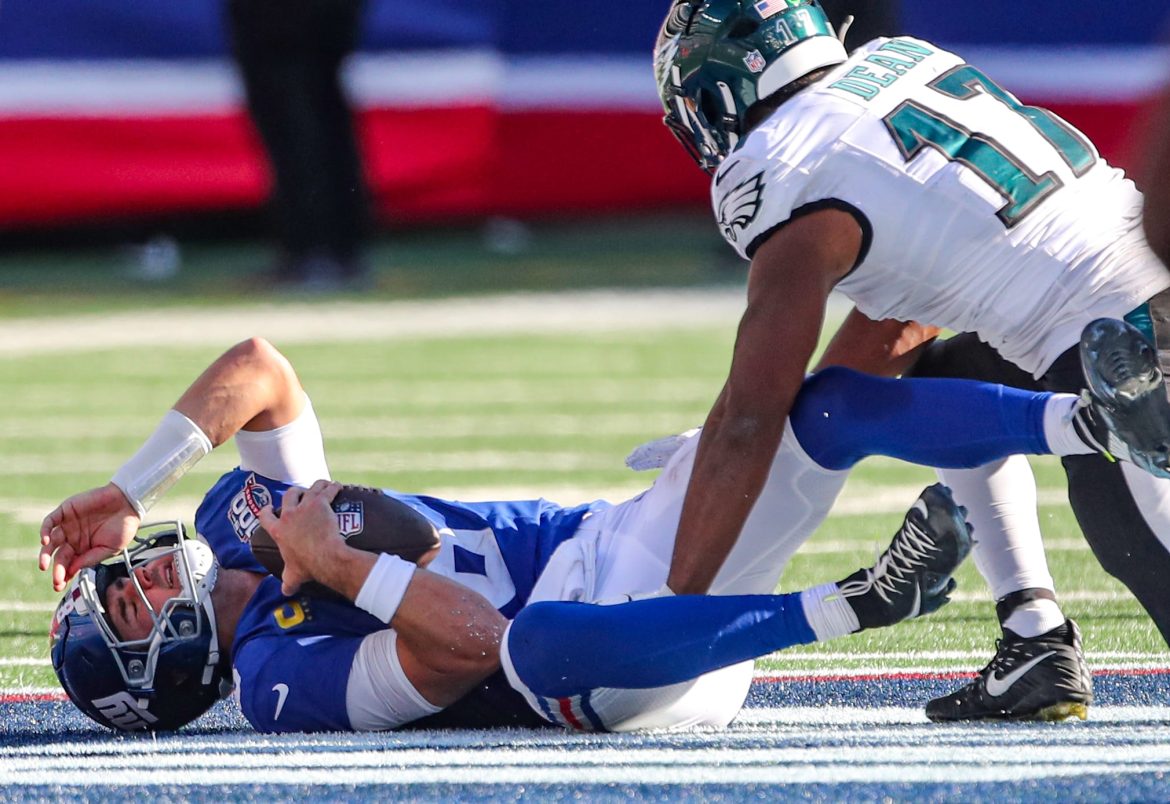 O quarterback do New York Giants, Daniel Jones (8), reage ao ser demitido pelo linebacker do Philadelphia Eagles, Nakobe Dean (17), durante o terceiro quarto, domingo, 20 de outubro de 2024, em East Rutherford, NJ. Esta foi a 7ª vez que Jones foi demitido pelo Águias, que venceram o jogo, 28-3.