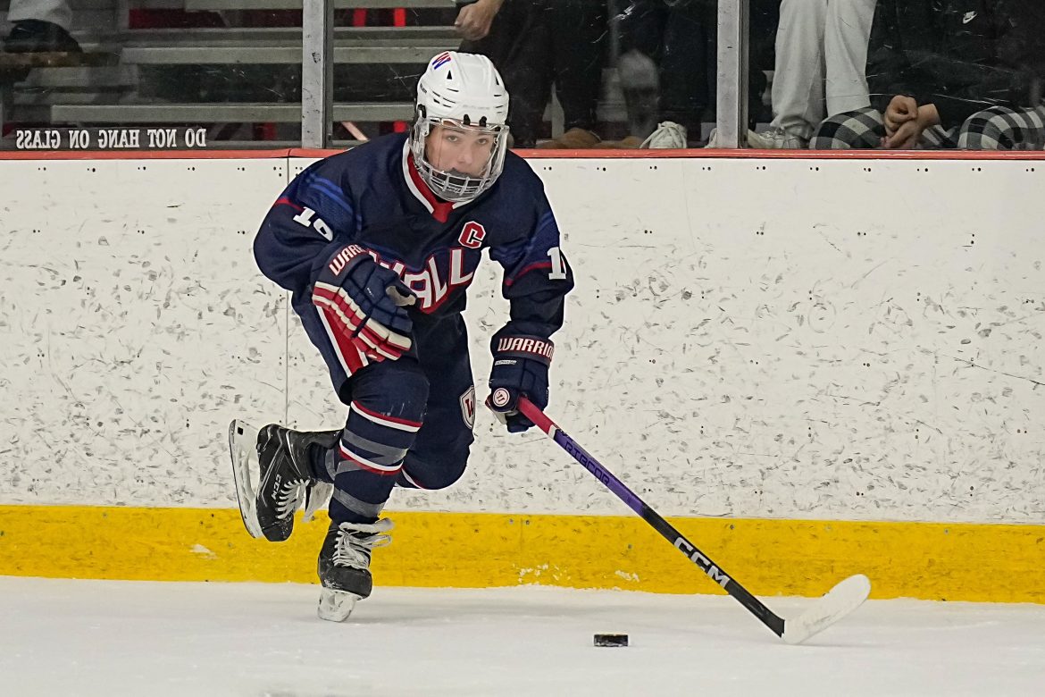 Mikey Hoarle (16) de Wall move o disco para fora da zona defensiva durante o jogo de hóquei no gelo masculino entre Ocean Township e Wall na Jersey Shore Arena em Wall Township, NJ, em 5 de janeiro de 2024.