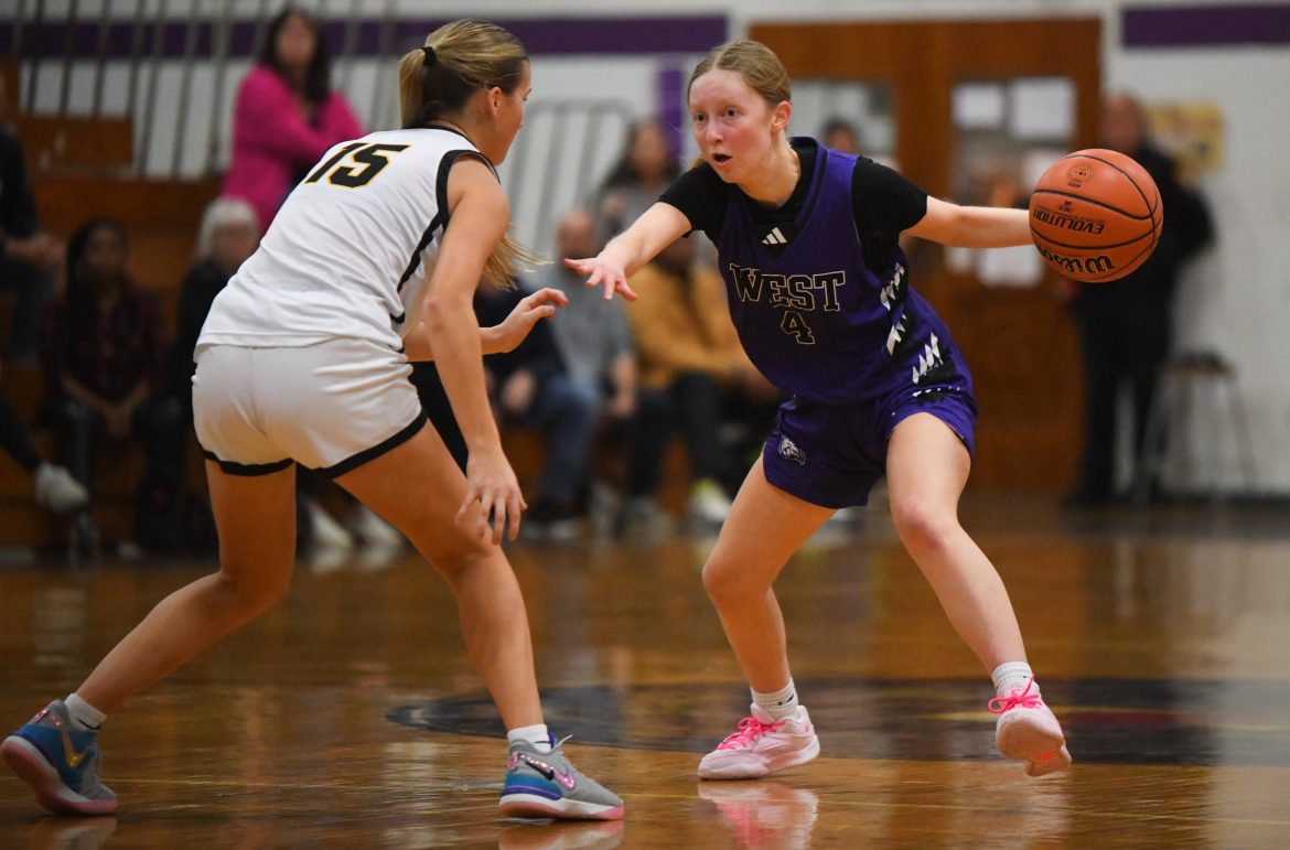 Molly Bovell, 4, de Cherry Hill West move a bola Julia Blong, 15, de Moorestown defendendo durante um jogo de basquete feminino na Cherry Hill West High School, quinta-feira, 19 de dezembro de 2024.
