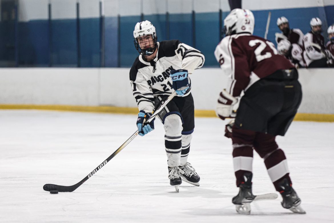 Jack Sheehan (21) de Pascack Valley-Hills pretende passar por Tyler Fitts (26) de Ridgewood durante o jogo de hóquei no gelo masculino entre Ridgewood e Pascack Valley-Hills no Sport O Rama Ice Rink em Monsey, NY na terça-feira, 6 de fevereiro, 2024.