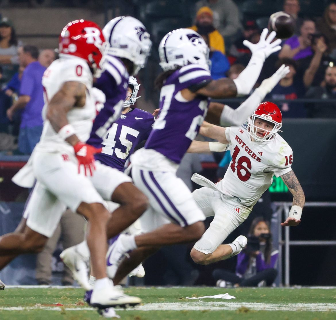 O quarterback do Rutgers, Athan Kaliakmanis (16), observa Daniel Cobbs (27), safety do Kansas State Wildcats, interceptar um passe mal lançado no terceiro quarto do Rate Bowl de 2024, quinta-feira, 26 de dezembro de 2024, em Phoenix. Os Wildcats conseguiram uma vitória impressionante por 44-41.
