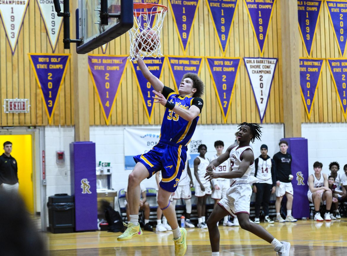 Jayden Hodge (33) de St. Rose dirige até a cesta enquanto é defendido por Nicolas Nsenkyire (2) da Rutgers Prep durante o jogo de basquete masculino na St. Rose High School em Belmar, NJ na segunda-feira, 23 de dezembro de 2024