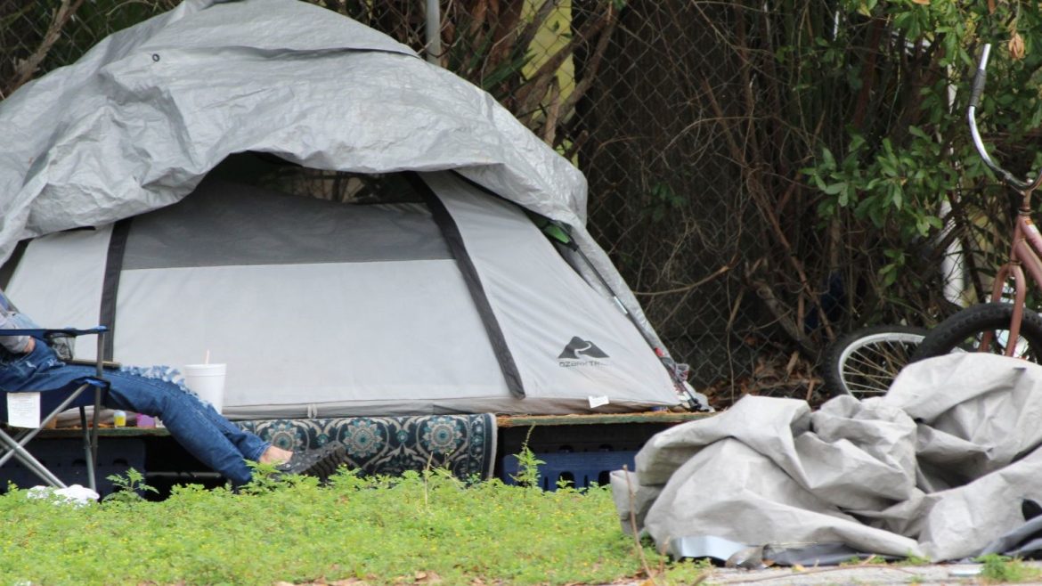 A homeless person with their tent.