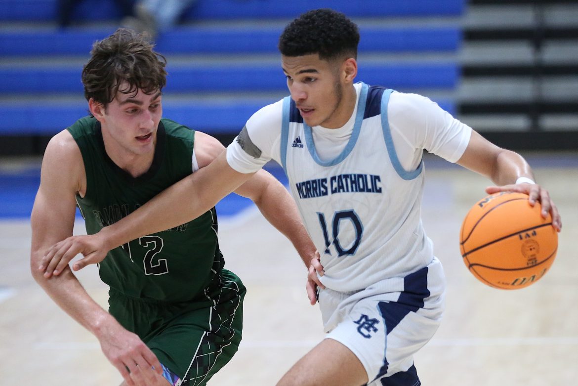Donnie Gregory, da Morris Catholic, procura passar por Luke Kennevan, do Camden Catholic, durante o jogo no Paul VI Winter Classic de sábado.