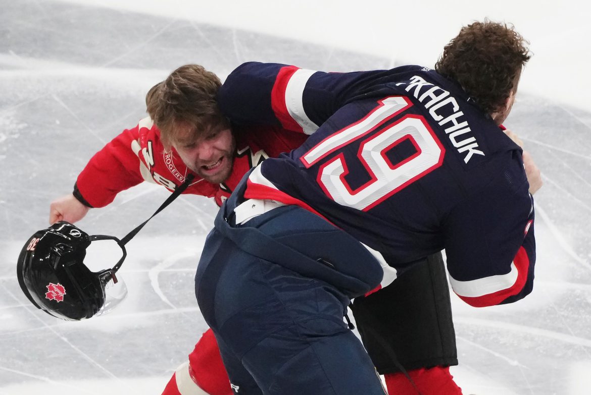 Brandon Hagel do Canadá, à esquerda, e Matthew Tkachuk (19) dos Estados Unidos lutam durante o primeiro período de 4 Nations enfrentando o jogo de hóquei em Montreal no sábado, 15 de fevereiro de 2025. (Christinne Muschi/The Canadian Press via AP)