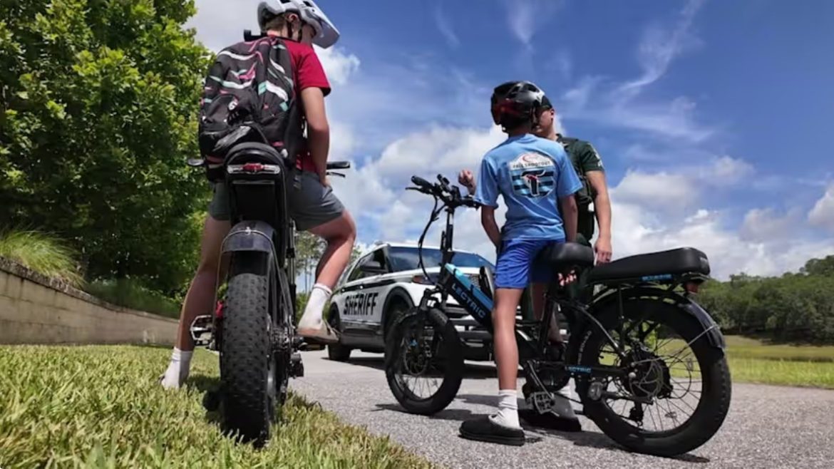 A police officer talks to children on e-bikes.